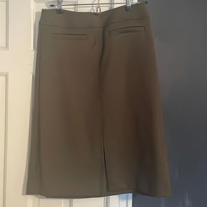 Olive green, below the knee skirt with front slit, back zip, and 2 pockets.